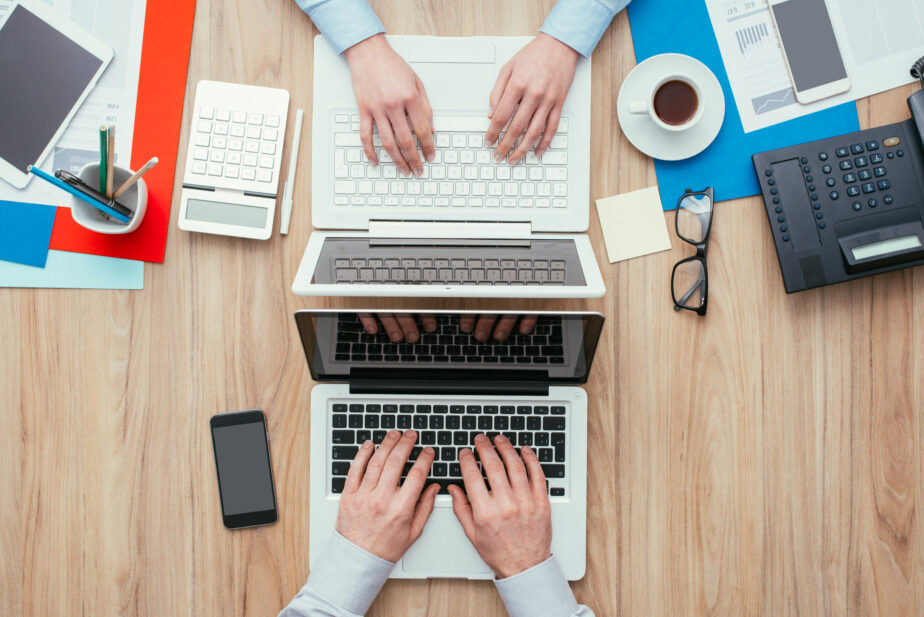 connected workspace with two people working  on their laptop